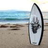 Honu World little surfboard model stuck in sand at beach